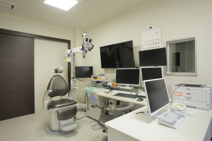 顕微鏡と複数のモニターを備えた耳鼻科診察室